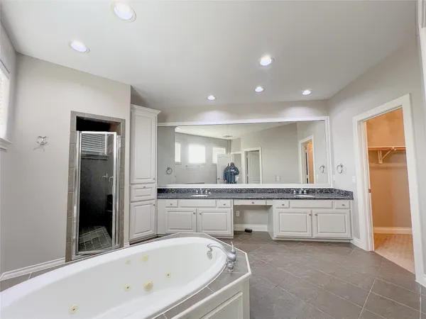 a large white kitchen with a sink and dishwasher a refrigerator with white cabinets