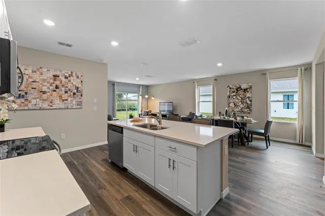 a large white kitchen with wooden floor