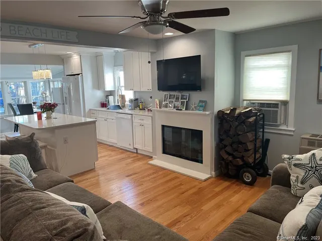 a living room with furniture a flat screen tv and a fireplace