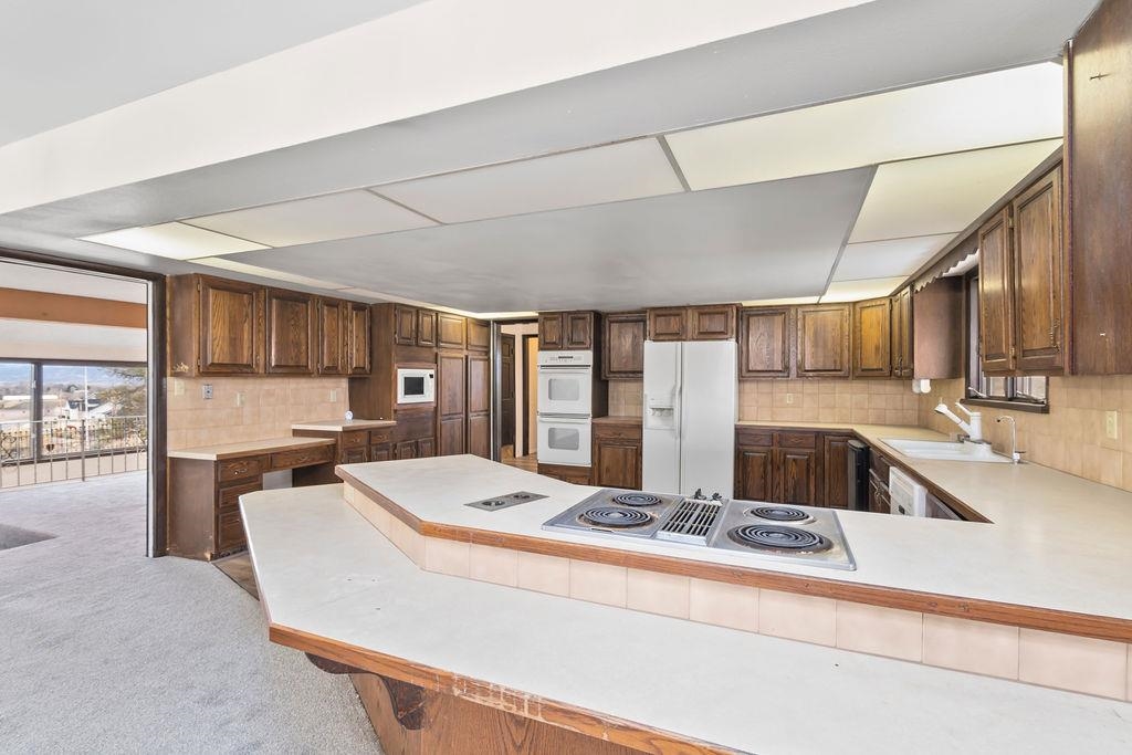 2590 I Road Grand Junction, CO 81505 - Photo 9 of 41 a large kitchen with kitchen island a large counter top space a sink stainless steel appliances and cabinets