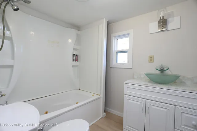 a bathroom with a granite countertop sink a toilet and bathtub