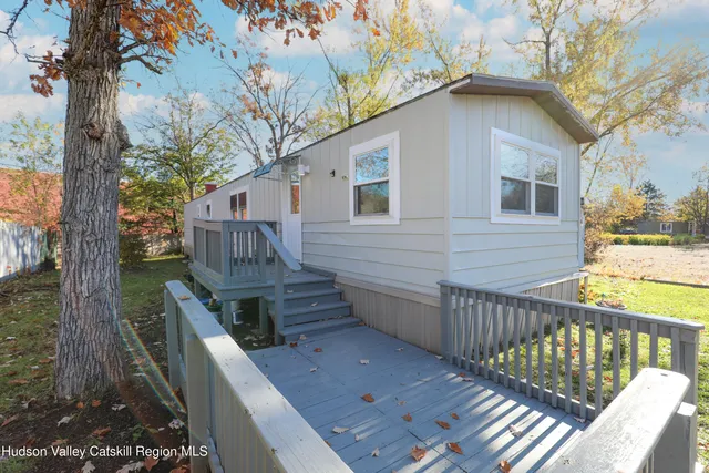 a view of a wooden chairs and a tree in the background