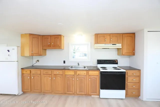 a utility room with stainless steel appliances wooden cabinets and a sink