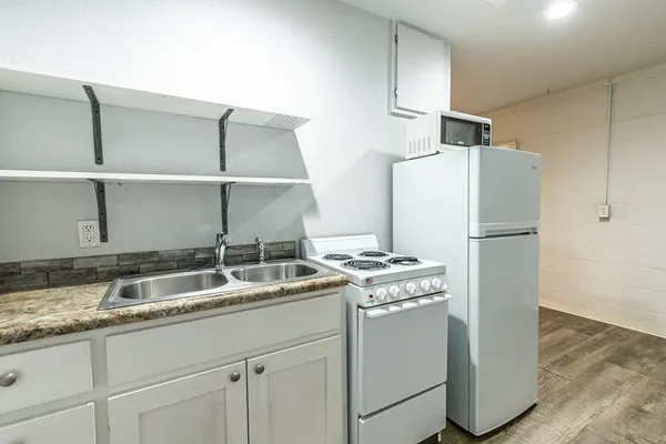 a kitchen with stainless steel appliances granite countertop a refrigerator a sink and a stove