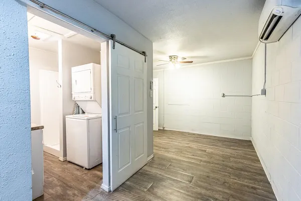 a view of a hallway with wooden floor and a cabinet