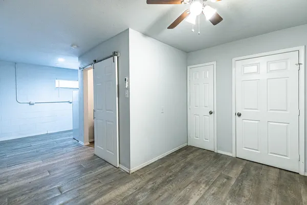 an empty room with wooden floor and windows