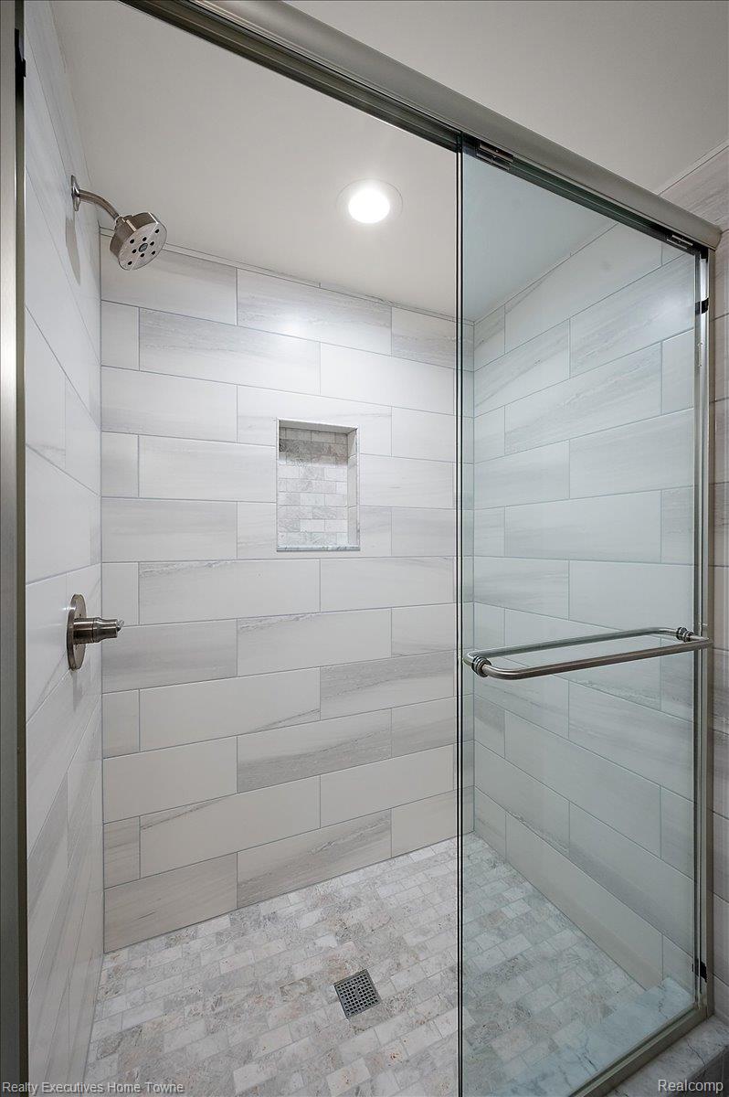 2919 North Addison Circle Rochester, MI 48306 - Photo 62 of 69 Glass-enclosed shower featuring white rectangular wall tiling, a built-in shower niche, and a tiled shower pan