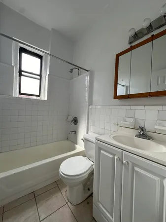 a bathroom with a toilet a sink a mirror a bathtub and vanity