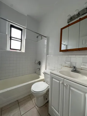 a bathroom with a toilet a sink a mirror a bathtub and vanity