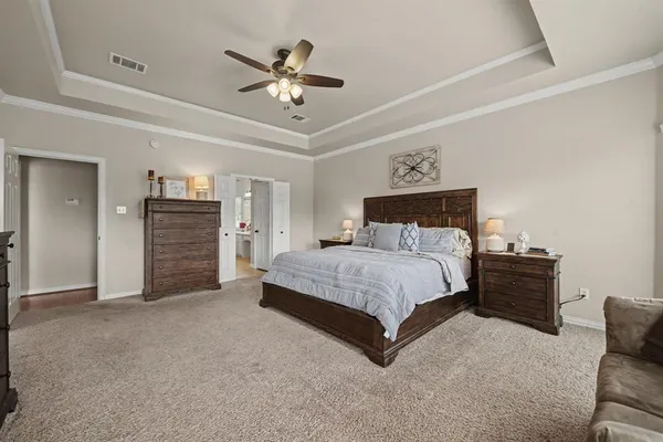 a spacious bedroom with a bed and ceiling fan