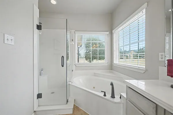 a bathroom with a tub sink and windows