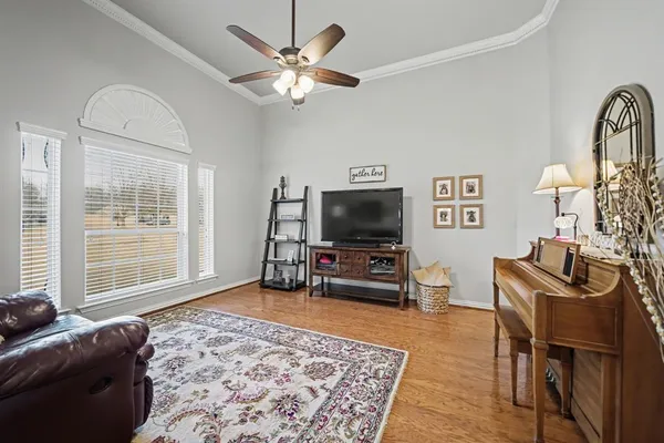a living room with furniture a flat screen tv and a window