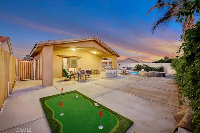 a view of a patio with couches and table and chairs under an umbrella