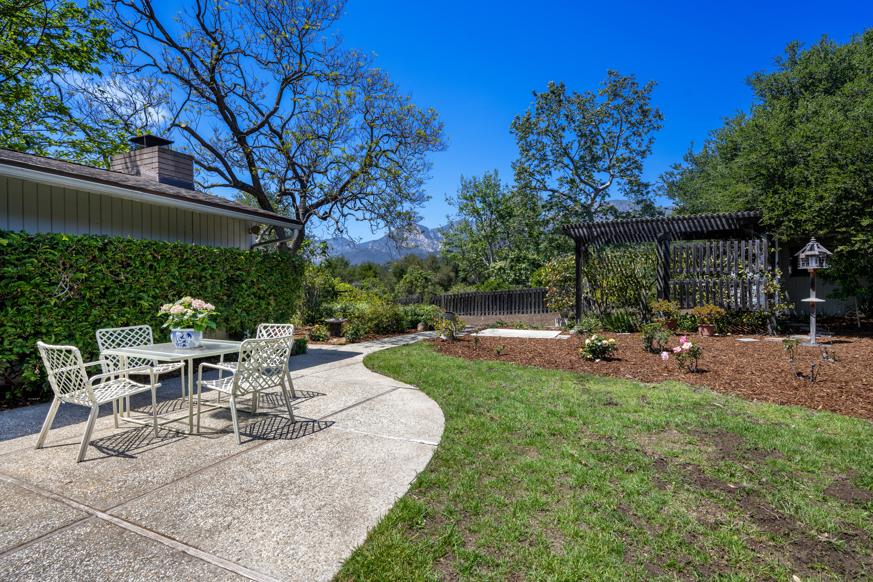 939 Mission Ridge Road Santa Barbara, CA 93103 - Photo 14 of 14 a view of a patio with table and chairs and potted plants and large trees
