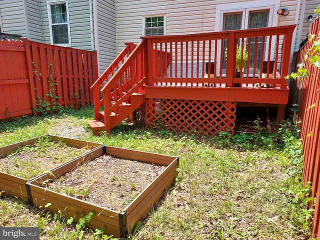 a view of a roof deck with wooden fence and plants