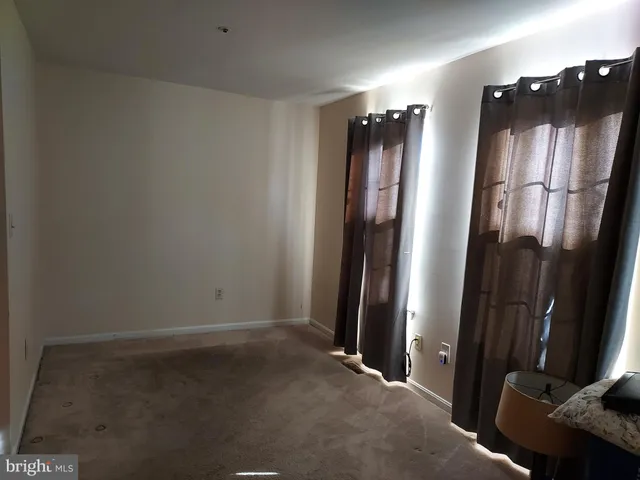 an empty room with wooden floor and a window