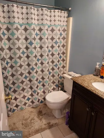 a bathroom with a granite countertop toilet and a sink