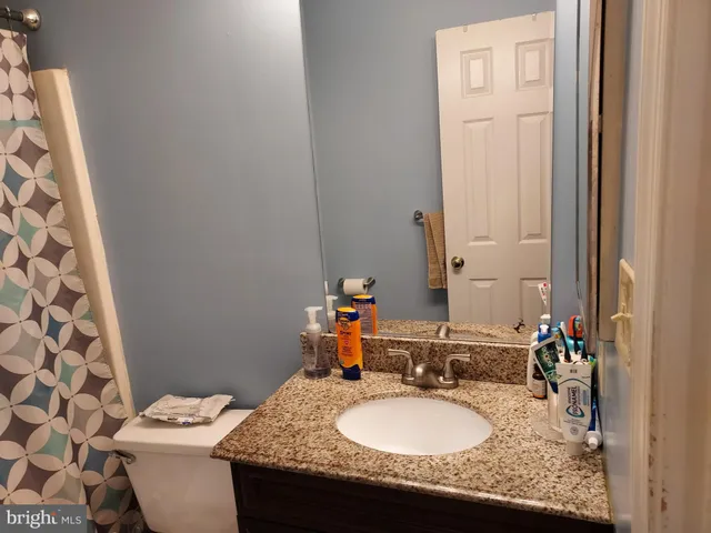 a bathroom with a granite countertop sink and a mirror
