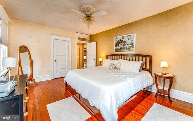 a bedroom with bed and wooden floor