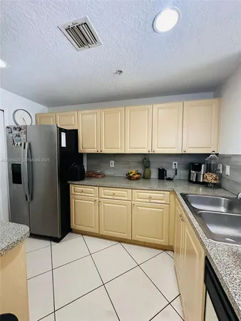 a kitchen with stainless steel appliances granite countertop a refrigerator sink and cabinets
