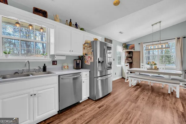a kitchen with white cabinets and white appliances