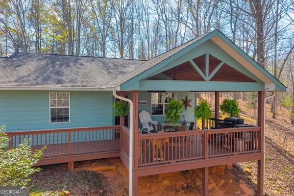 a view of house with a deck and a yard