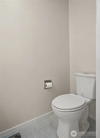 a white toilet sitting next to a white wall
