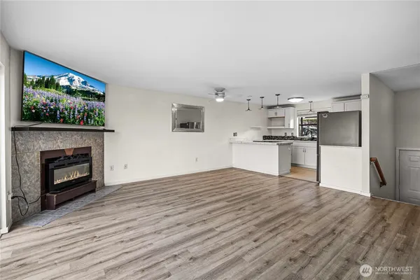a view of empty room with wooden floor and fireplace