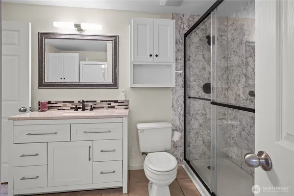 a bathroom with a sink a toilet and shower