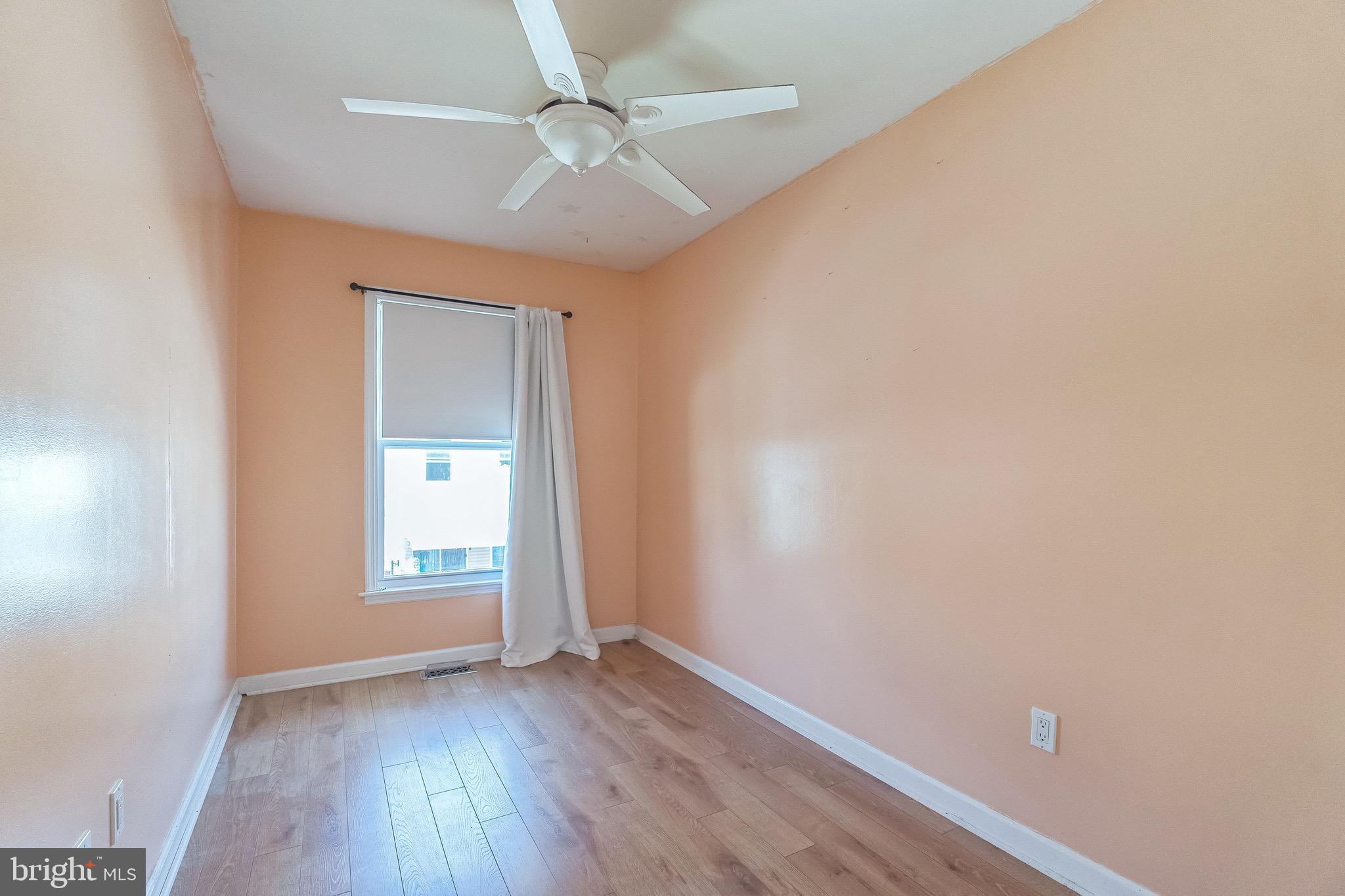 3566 Edgemont Street Philadelphia, PA 19134 - Photo 19 of 25 an empty room with wooden floor ceiling fan and windows