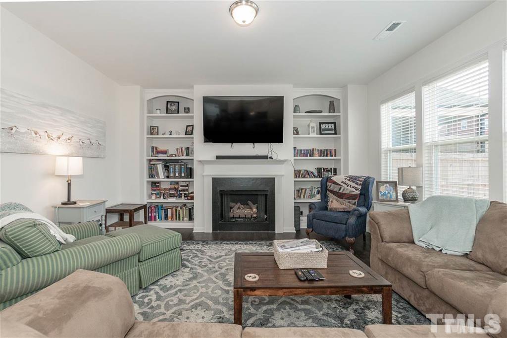 42 Griffith Place Clayton, NC 27520 - Photo 11 of 26 a living room with furniture a flat screen tv and a fireplace