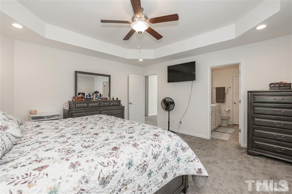 42 Griffith Place Clayton, NC 27520 - Photo 16 of 26 a bedroom with a bed and a large mirror