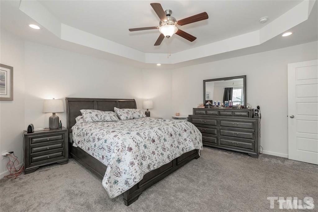 42 Griffith Place Clayton, NC 27520 - Photo 18 of 26 a bedroom with a bed and a chandelier
