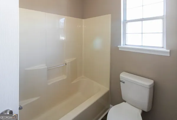 a white toilet sitting next to a bath tub