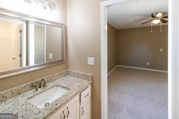 a bathroom with a granite countertop sink and a mirror