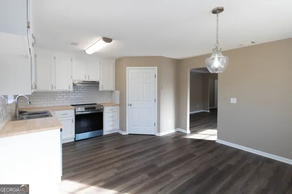 a view of a kitchen center island wooden floor and cabinets