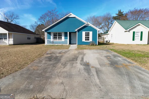 a view of a house with backyard and garden