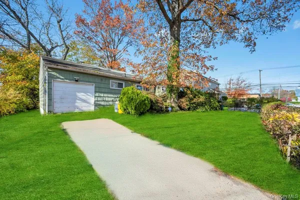 a view of a wooden house with a big yard and large trees