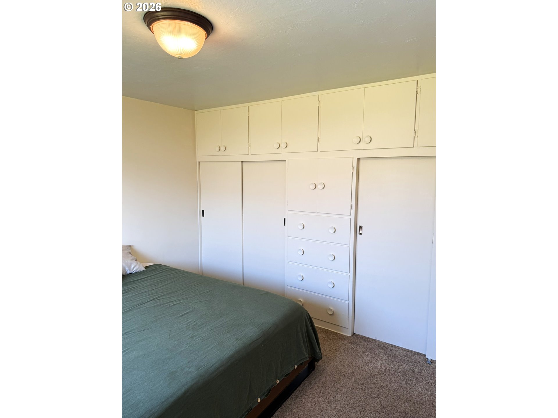1179 6th Street Florence, OR 97439 - Photo 21 of 26 a bedroom with a bed and cabinets