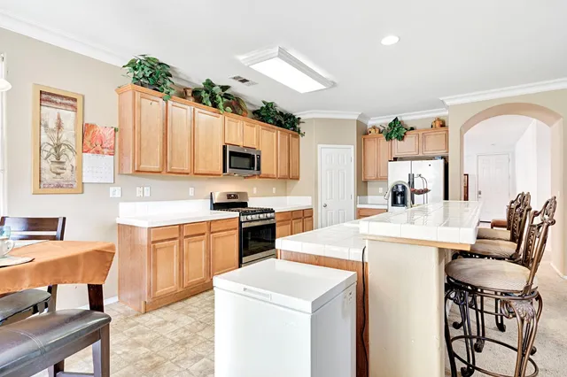 a kitchen with a stove a sink a microwave a dining table and chairs