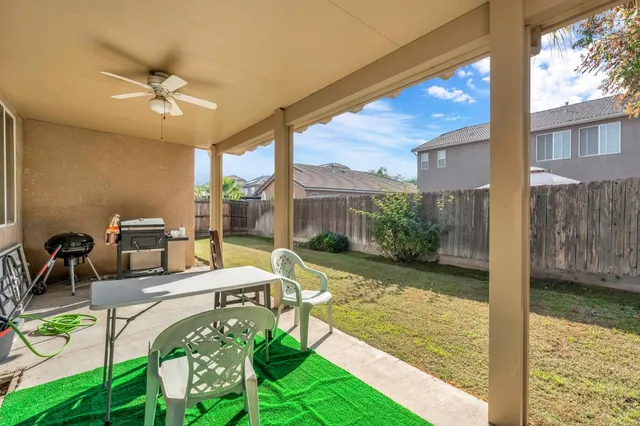 a view of a patio with table and chairs potted plants with floor to ceiling window