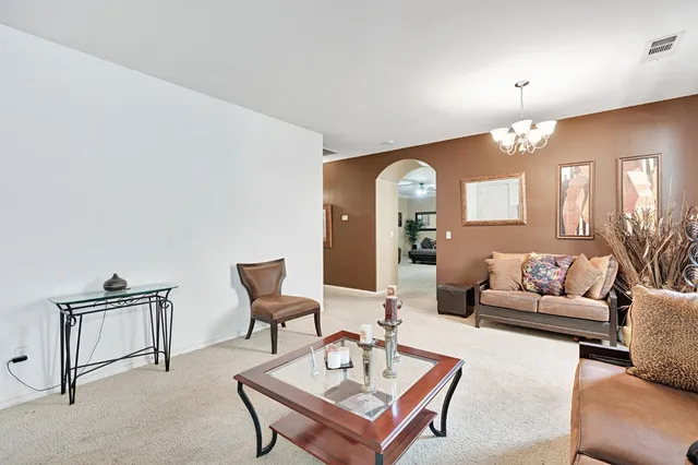 a living room with furniture and a chandelier