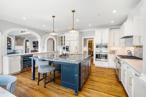 a kitchen with stainless steel appliances granite countertop a stove and white cabinets