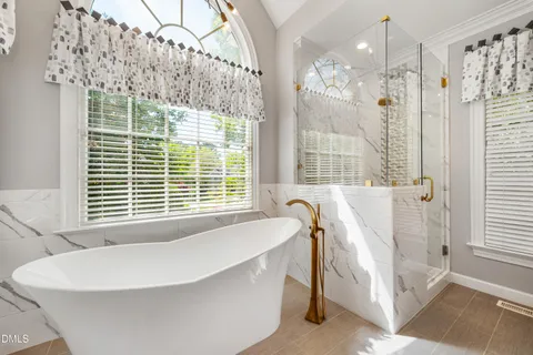a bathroom with a granite countertop shower and a mirror