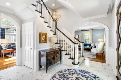 a dining room with furniture a chandelier and wooden floor