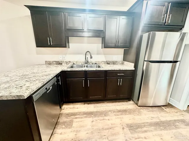 a kitchen with a sink a refrigerator and a cabinets