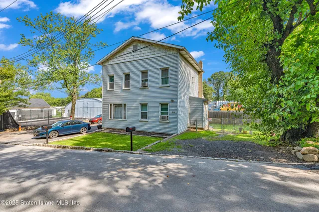a view of backyard of house and car parked