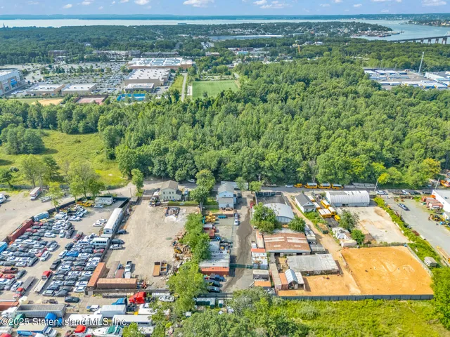 an aerial view of residential houses with outdoor space and parking