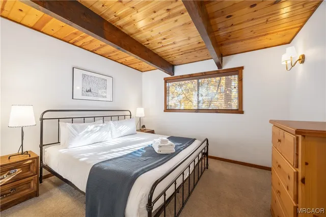 a bedroom with a bed and a dresser next to a window