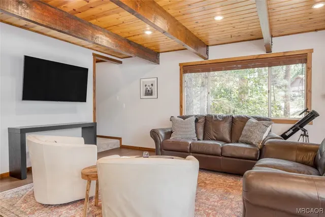 a living room with furniture a flat screen tv and a large window